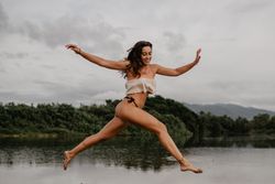 Smiling woman jumping over water