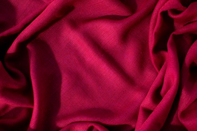 Red fabric wavy crumpled background texture with copy space.