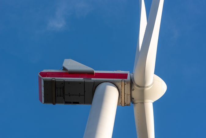 Wind turbine low angle view close-up, isolated on the blue sky
