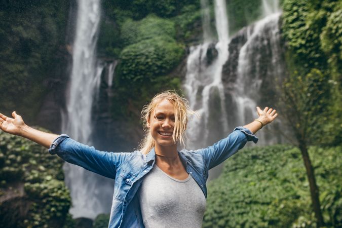 Female tourist with tropical waterfall in background