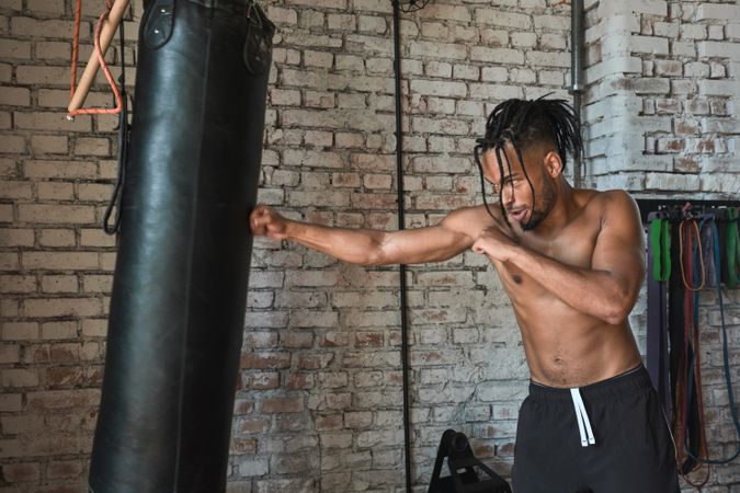 Black guy boxing in gym
