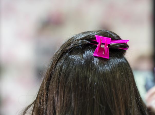 Top of brunette hair with bright pink clip