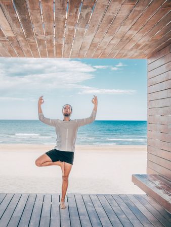 Man doing yoga by the beach