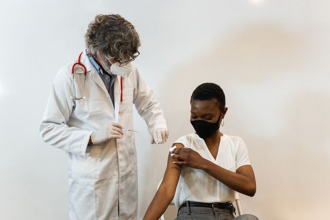 Doctor making injection for Black woman patient