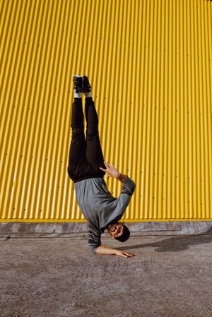 Man performing handstand near wall