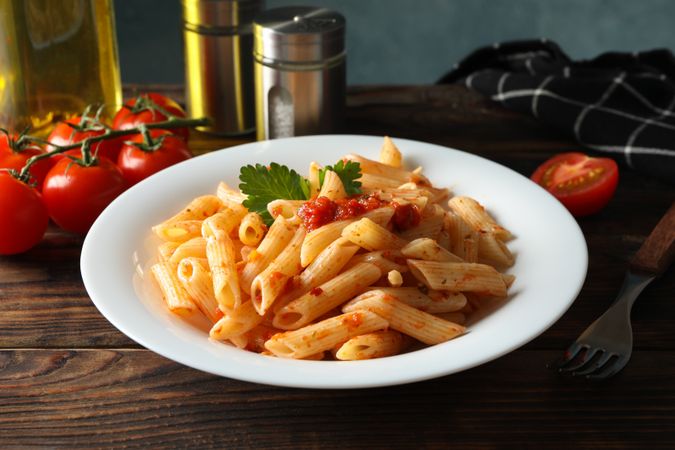 Composition with plate of tasty pasta on wooden background. Cooking pasta