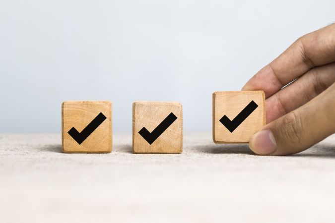 male hand put wooden blocks with checkmark symbol