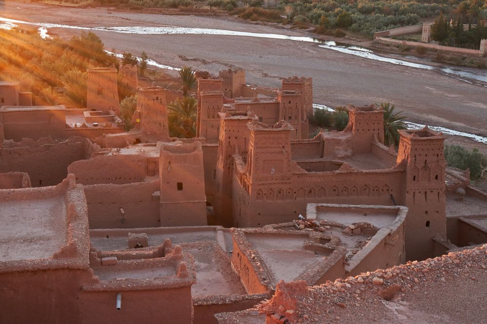 Ancient city near river in desert with sunshine