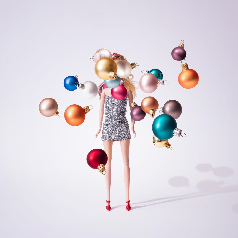 Doll in silver glittering dress with colorful Christmas baubles decoration
