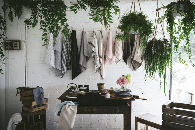 Table with flowers in vase on trays near towels hanging on thread