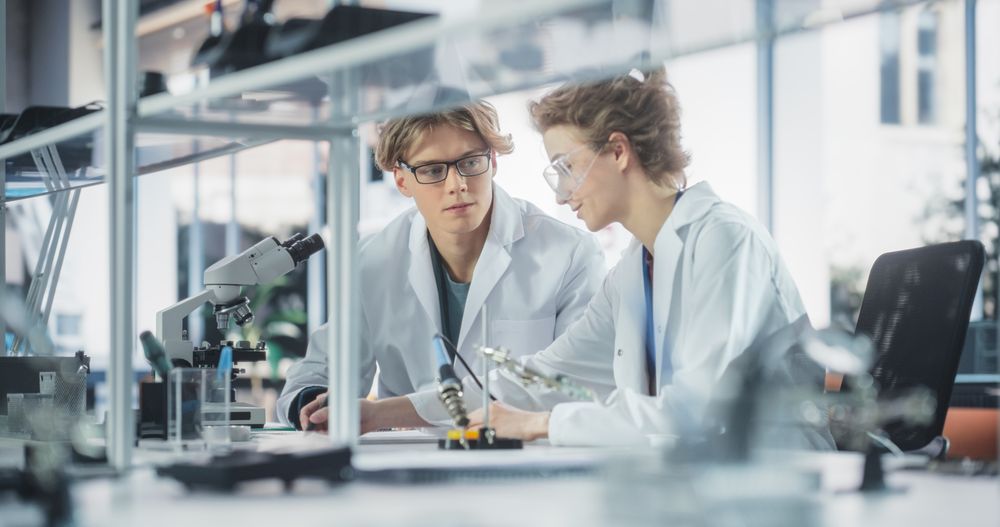 Young Female and Male Students Working Together in Laboratory Classroom, Collaborating on a College Research Project.