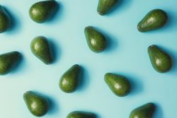 Whole avocado pattern on a pastel blue background