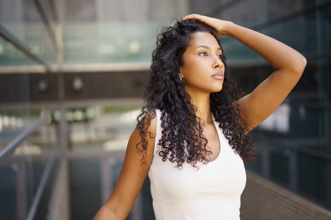 A thoughtful young woman in an urban setting exudes confidence, elegance, and style