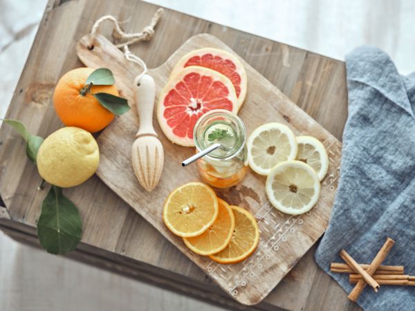 Fresh drink and sliced fruits on cutting board