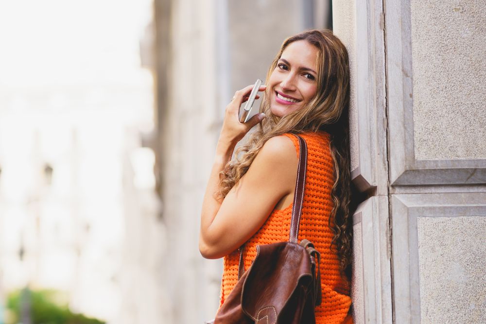 Latin woman leaning on an urban facade in the city