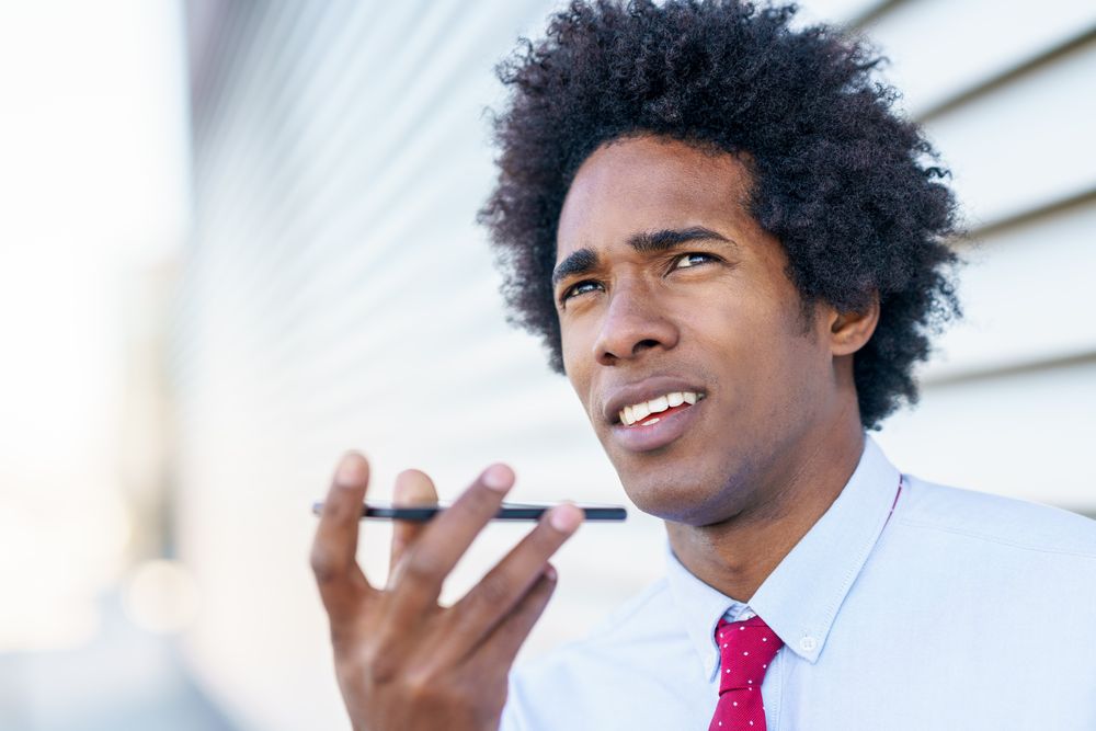 Serious man taking voice notes on his phone