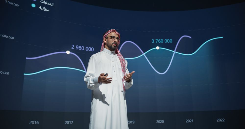 Successful Middle Eastern Speaker Presenting a New Product, Showing Infographics, Statistics Animation on Big Screen.