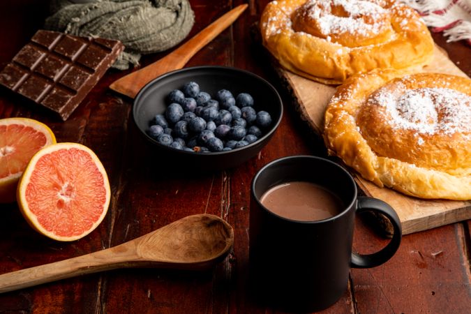 Fresh fruits near bun and hot drink