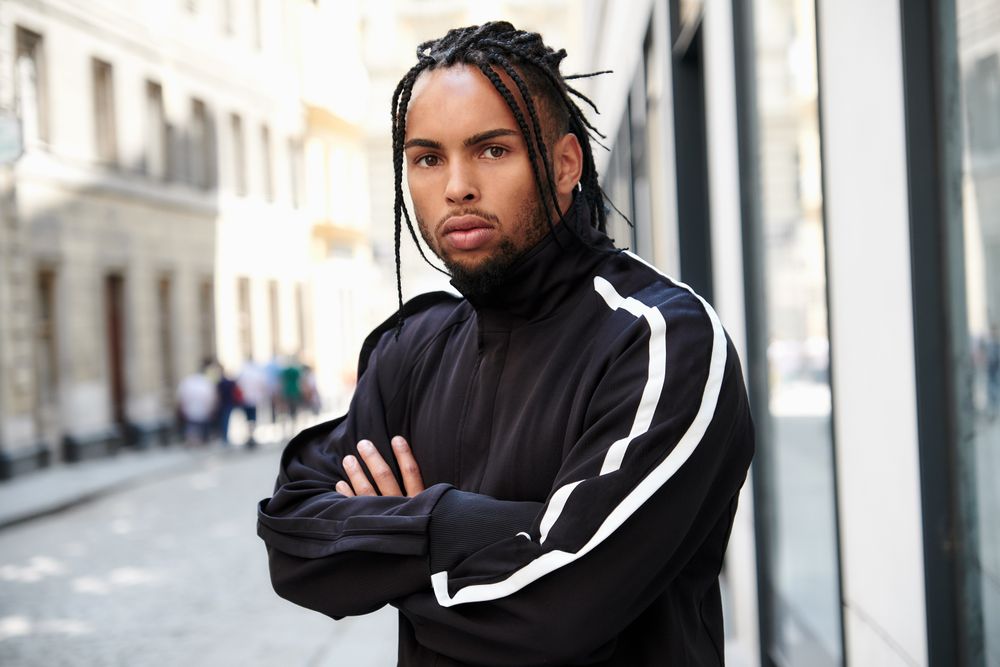 Black male standing with arms crossed