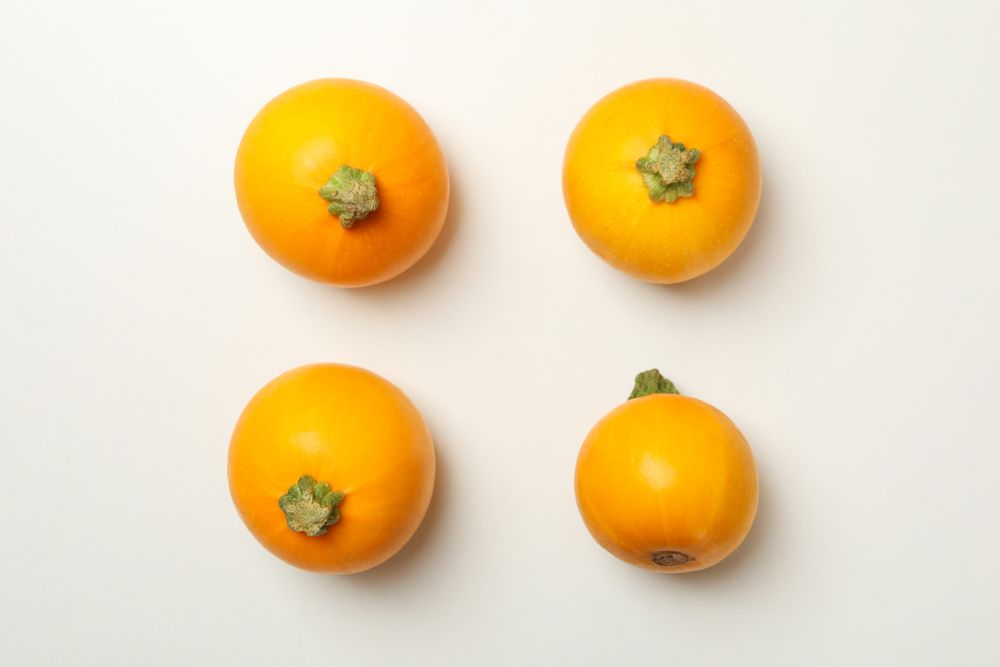 Four zucchini on blank background, top view