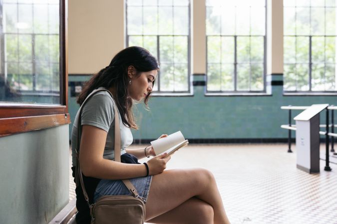 Woman reading a book in a train station