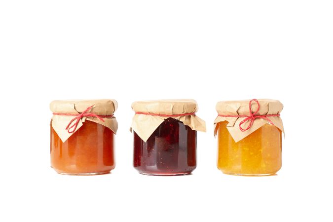 Glass jars with jam isolated on blank background