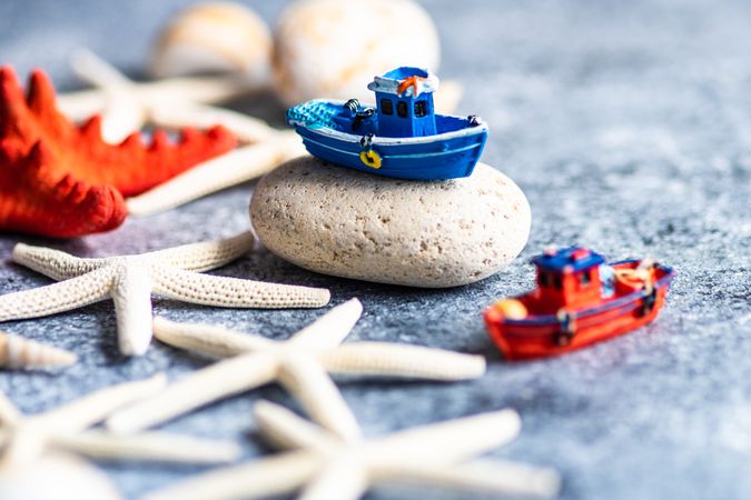 Summer concept with sea shells and fishing boat toy