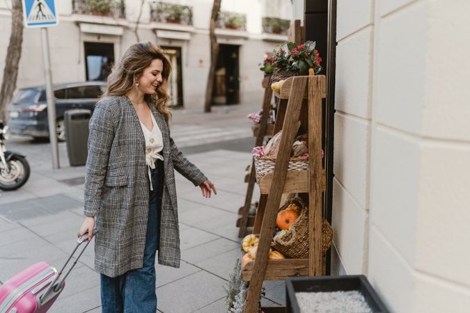 Smiling female tourist near grocery shop