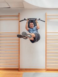 Smiling man exercising on bars
