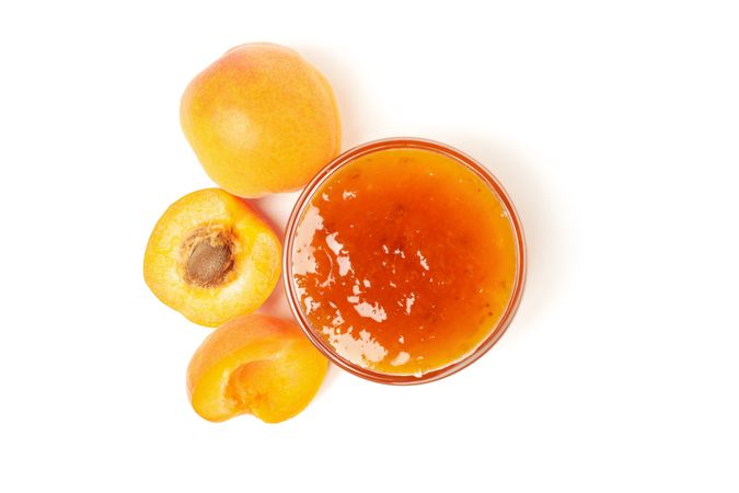Glass bowl with apricot jam isolated on blank background