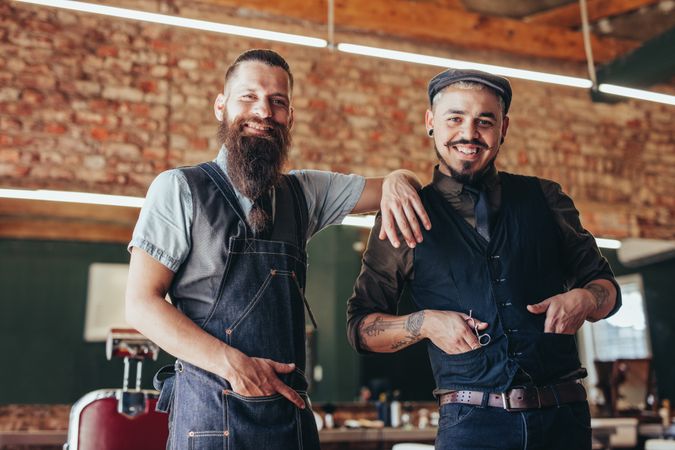 Hipster barbers standing together in male salon