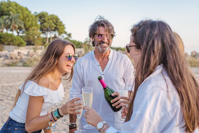 Happy family drinking wine on beach