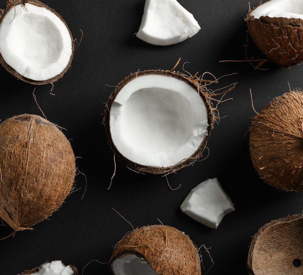 Flat lay composition with coconuts on dark background