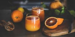 Two glasses of freshly squeezed blood orange juice, wide composition