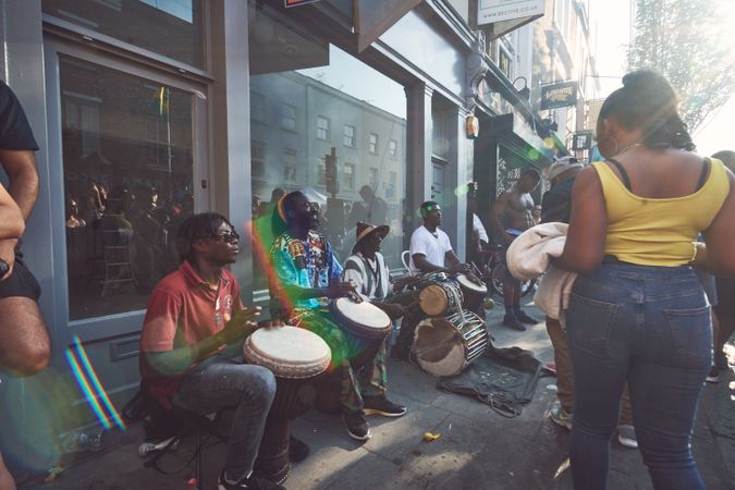 London, England, United Kingdom - August 25th, 2019: Woman walks by men playing drums on the street