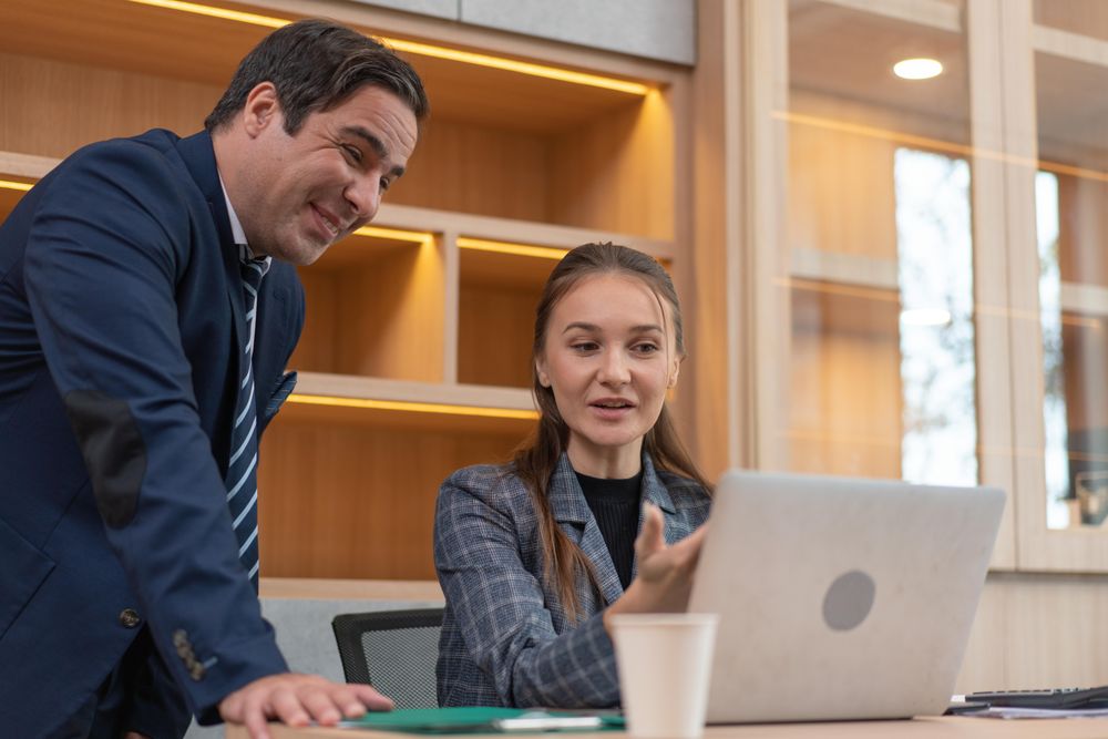 Two colleagues discussing work at a desk