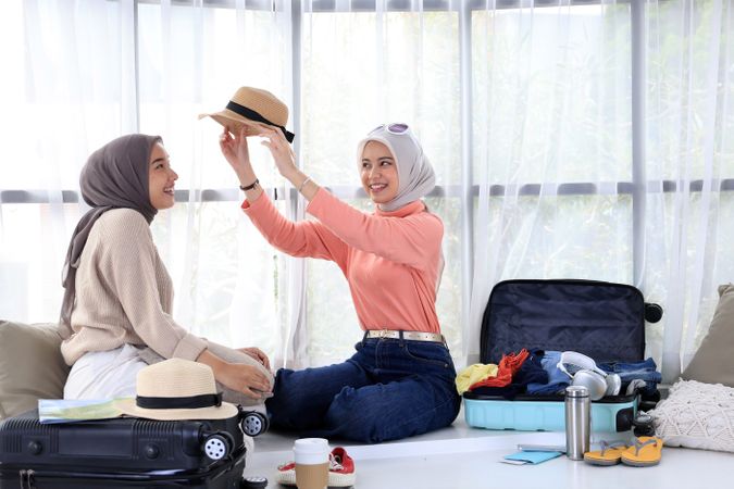 Trying on a Hat on Her Friend to See Which Outfit  Match