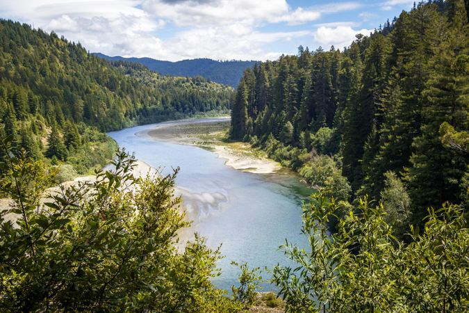 Low river running through mountainous trees