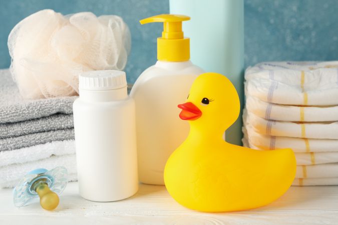 Baby hygiene accessories on wooden table against blue background
