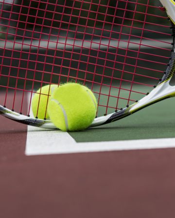 Close up of tennis racket and ball on court