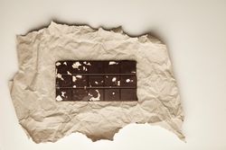 Top view of chocolate bar with almonds on table