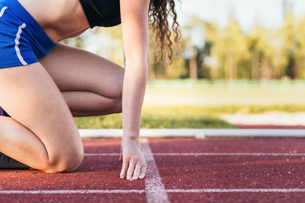 Focused female athlete prepared to run on an athletics track