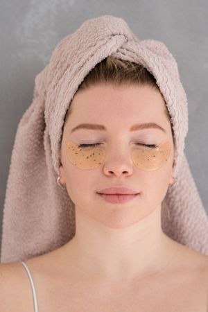 Applying eye patches in skincare routine.