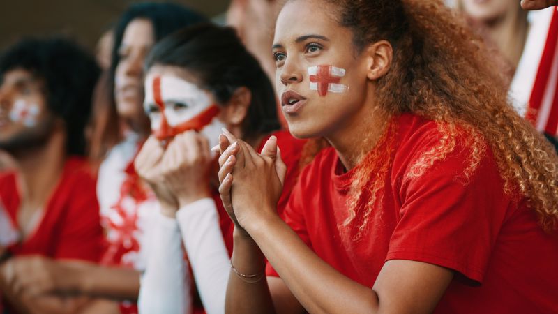 Anxious looking female soccer fans watching the game at stadium