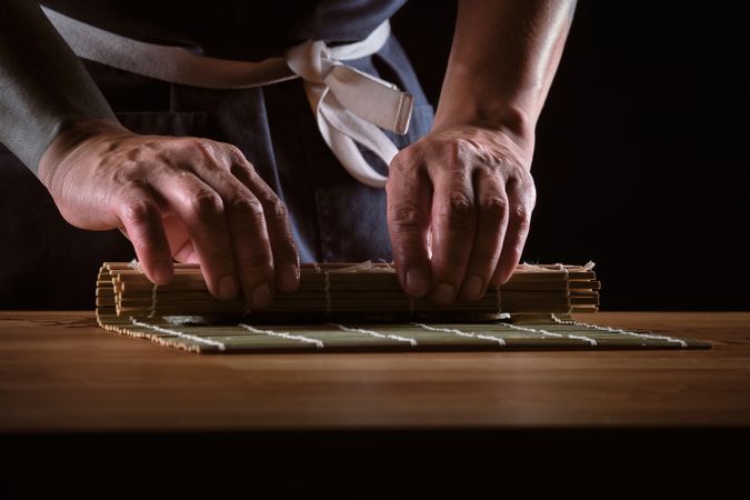 Male shushi man hands preparing different pieces of makis