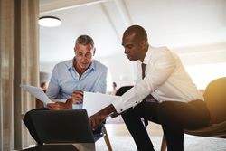 Two men going through a presentation together at work