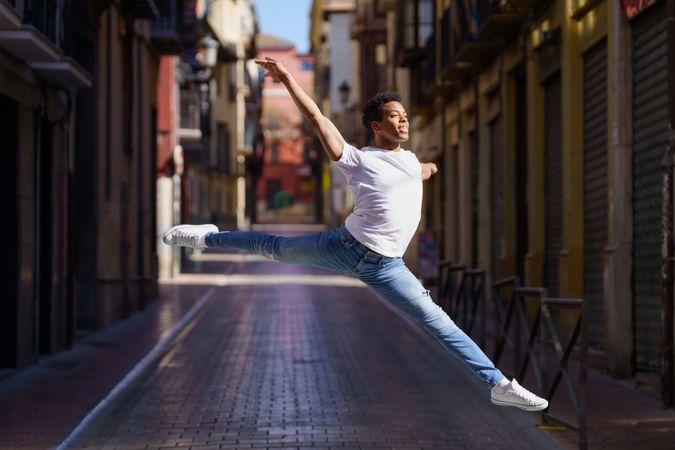 Male dancer leaping on an empty European street