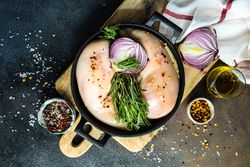 Top view of raw chicken in pan ready to cook on cutting board with copy space