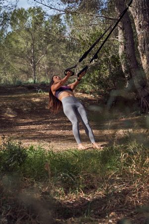 Barefoot sportswoman in activewear doing fitness in nature