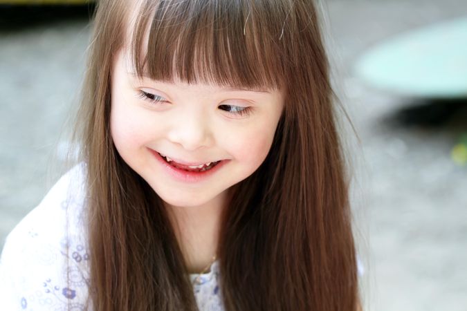 Portrait of a young girl with Down syndrome looking away from the camera
